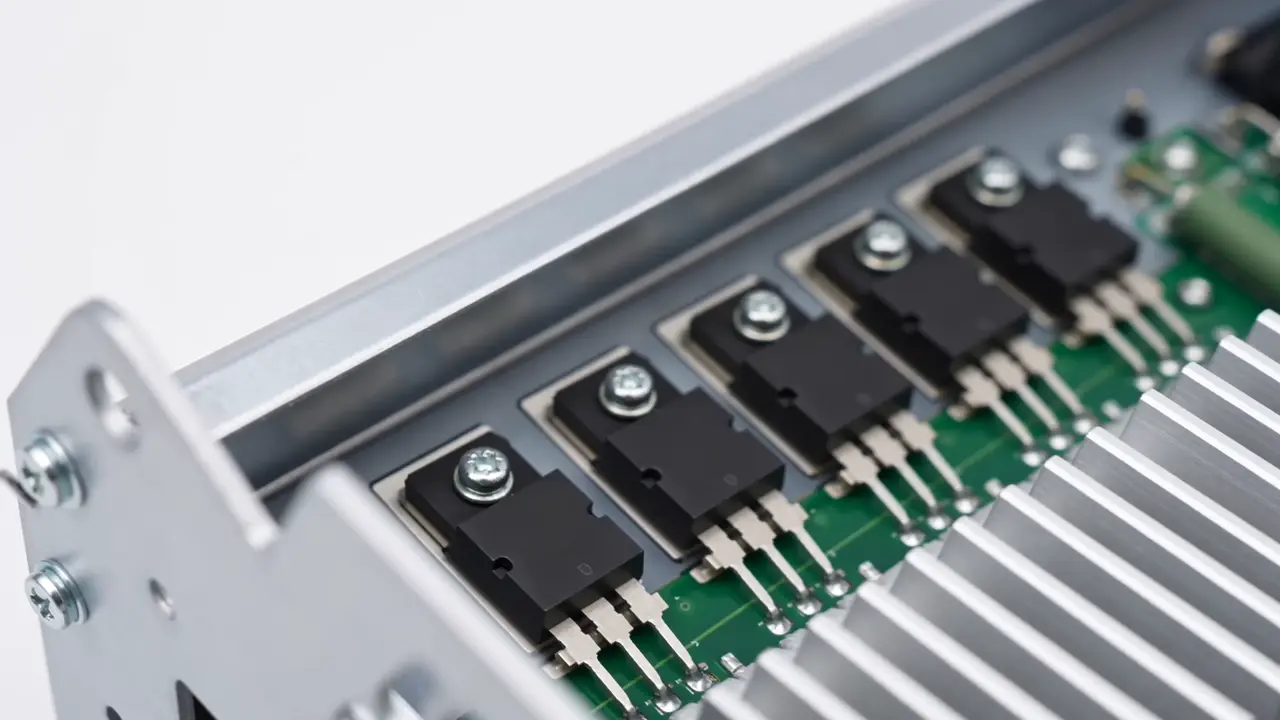 Close-up of servo drive PCB — IGBT modules, gate driver section and DC bus capacitors